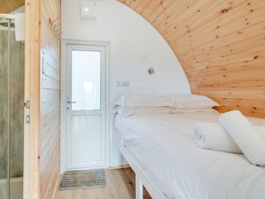 A bedroom with a bed a door and a shower at Carlton Manor Pod 8 in Aldbrough