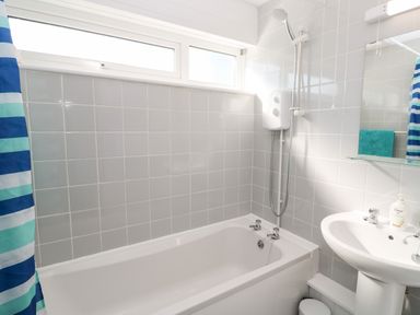 A bathroom with a bathtub shower and sink at 39 Manorcombe Bungalows Honicombe Holiday Village near Drakewalls