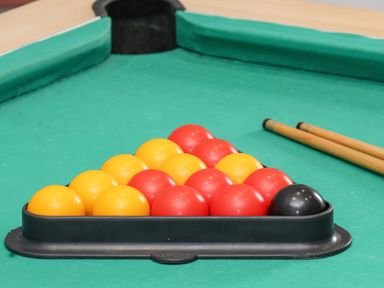 A close-up of a snooker table with red, yellow, and black balls arranged in a triangle at The Old Police House in Withernsea