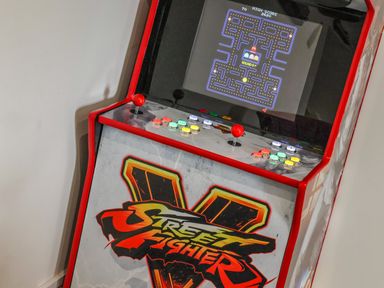 An arcade game machine with a pacman game on the screen and street fighter v artwork at The Old Police House in Withernsea