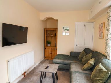 A living room with a television and a sofa at Hazelgarth House in Hunmanby