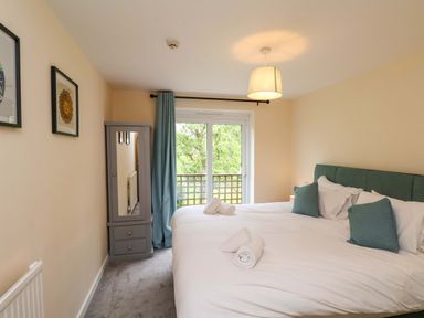 A bedroom with two beds and a mirror at Hazelgarth House in Hunmanby
