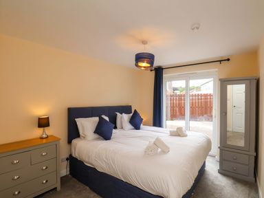A bedroom with a bed and wardrobe at Hazelgarth House in Hunmanby