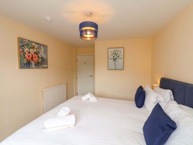 A bedroom with a bed and paintings on the walls at Hazelgarth House in Hunmanby