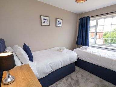 A bedroom with two beds and a window at Hazelgarth House Hunmanby