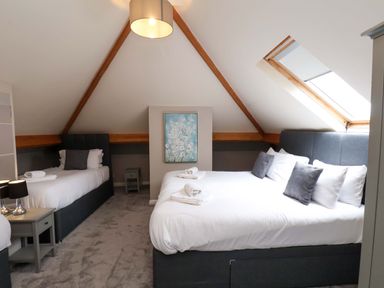 A bedroom with two beds and a window at Hazelgarth House Hunmanby