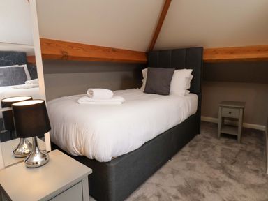 A bedroom with a bed and bedside table at Hazelgarth House in Hunmanby