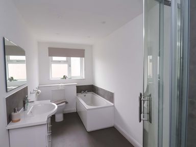 A bathroom with a bath tub and a sink at Hazelgarth House in Hunmanby
