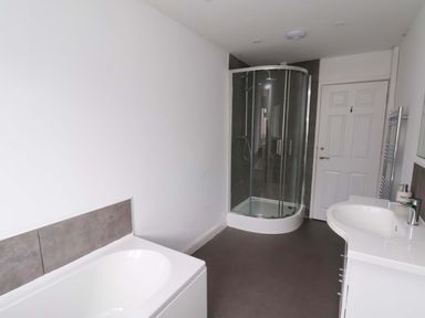 A bathroom with a bathtub, shower, and washbasin at Hazelgarth House in Hunmanby