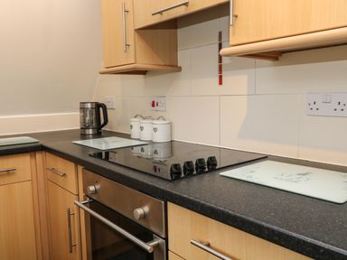 A kitchen countertop with a stovetop oven kettle and storage canisters at Valley Lodge 33 in Callington near Gunnislake