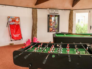A game room with a foosball table basketball game and a pool table at Cosy Cottage in Broadwoodwidger near Lifton