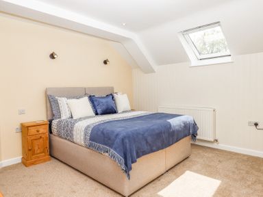 A bedroom with a double bed bedside table and skylight window at Bunts Barn Northlew near Hatherleigh