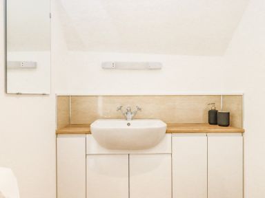 A bathroom sink with cabinets underneath and soap dispenser on the counter at Bunts Barn Northlew near Hatherleigh