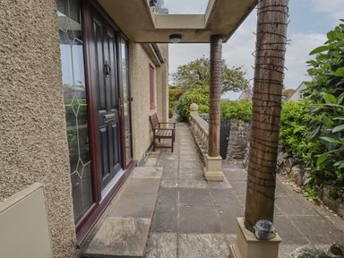 A porch with two wooden columns and a bench beside a black door at Spernenwyn in St Ives