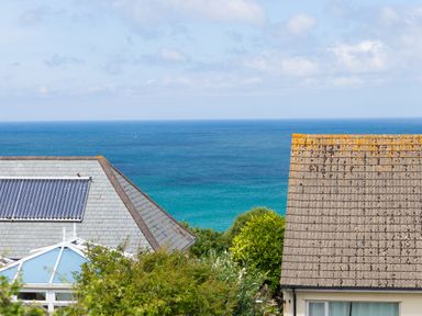 View of the ocean with roofs of houses and greenery in the foreground at Spernenwyn in St Ives