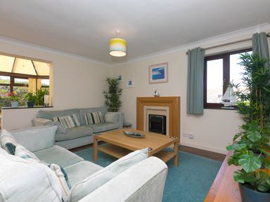 A living room with sofas coffee table fireplace and plants at Spernenwyn in St Ives