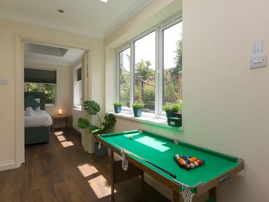 A room with a small pool table by a window and a bedroom visible through an open door at Spernenwyn in St Ives