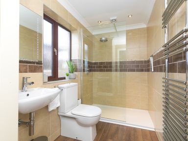 A bathroom with a shower area a toilet a sink and a heated towel rail at Spernenwyn in St Ives