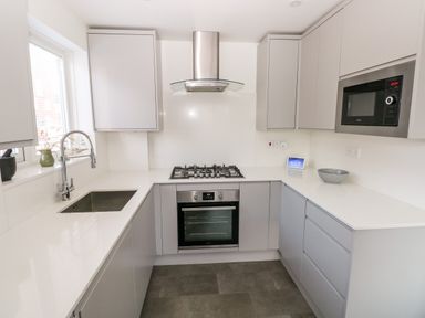 A kitchen with a stove oven microwave sink and cabinets at 12 Clos Yr Wylan Barry
