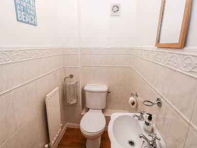A bathroom with a toilet sink mirror radiator and a towel at 12 Clos Yr Wylan in Barry