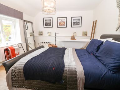 A bedroom with a bed and a bathtub at Pennant Cottage in Llithfaen