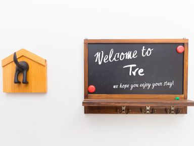A welcome sign and decorative hooks in the entryway at Carines Barns - Tre
