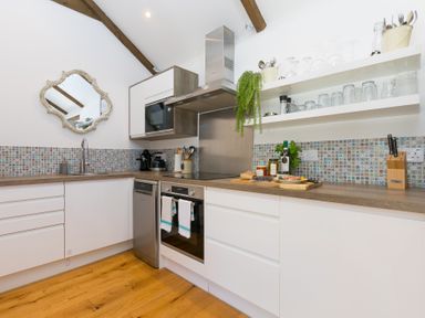 A kitchen with cabinets and appliances at Carines Barns - Tre in Cubert