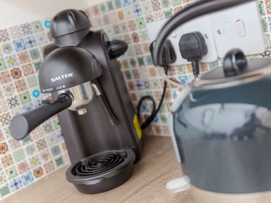 An espresso machine and kettle on a countertop at Carines Barns - Tre in Cubert