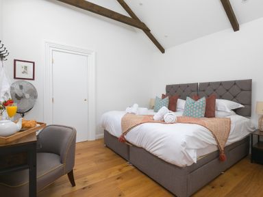 A bedroom with two beds and chairs at Carines Barns - Tre in Cubert