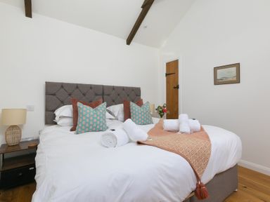 A bedroom with a bed and decorative items at Carines Barns - Tre, Cubert