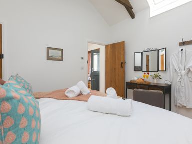 A bedroom with a bed and dressing table at Carines Barns - Tre in Cubert