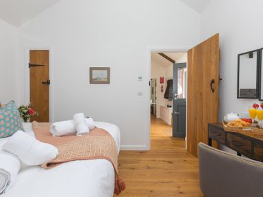 A bedroom with a bed and a table at Carines Barns - Tre in Cubert