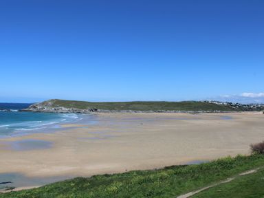 A beach with grass and water at Carines Barns - Tre in Cubert