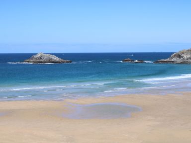 A beach with waves and rocks at Carines Barns - Pol, Cubert