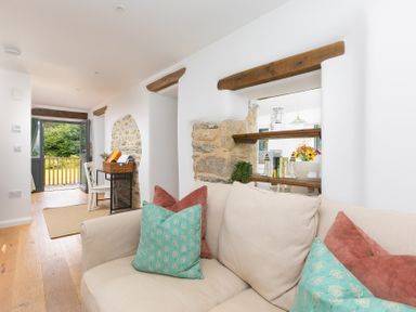 A living room with a sofa and cushions at Carines Barns - Pen, Cubert