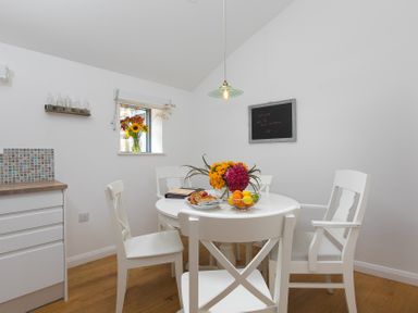 A dining room with a table and chairs at Carines Barns - Pen, Cubert