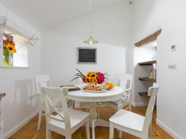 A dining room with a table and chairs at Carines Barns - Pen, Cubert