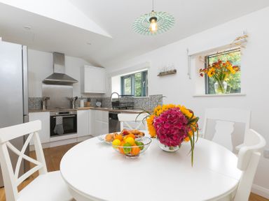 A kitchen with a table and fruit bowl at Carines Barns - Pen, Cubert