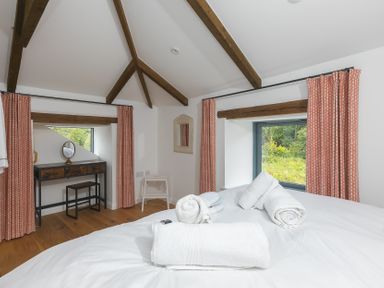 A bedroom with a bed and a desk at Carines Barns - Pen, Cubert