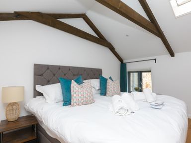 A bedroom with a bed and nightstand at Carines Barns - Pen, Cubert