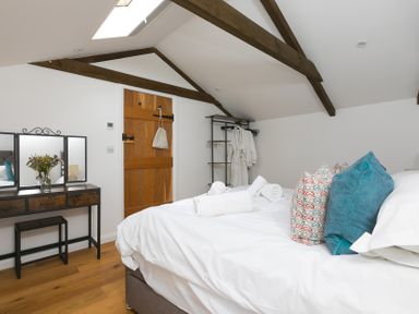 A bedroom with a bed and mirror at Carines Barns - Pen in Cubert
