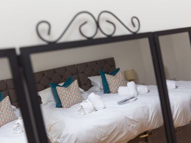 A bedroom with a bed and decorative pillows at Carines Barns - Pen, Cubert