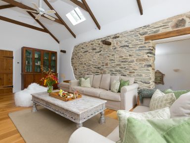 A living room with a sofa and coffee table at Carines Barns - Wesley Barn, Cubert