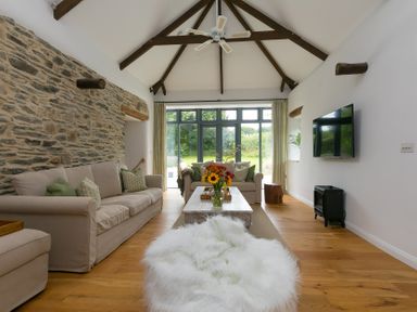 A living room with a sofa and coffee table at Carines Barns - Wesley Barn, Cubert