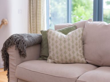 A sofa with cushions and a throw blanket at Carines Barns - Wesley Barn in Cubert