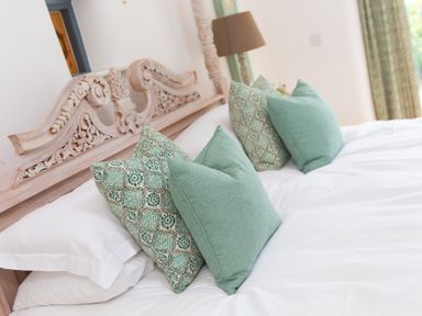 A bedroom with a bed and pillows at Carines Barns - Wesley Barn, Cubert