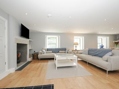 A living room with two sofas a coffee table a fireplace and a television at Cob Cottage near Rock