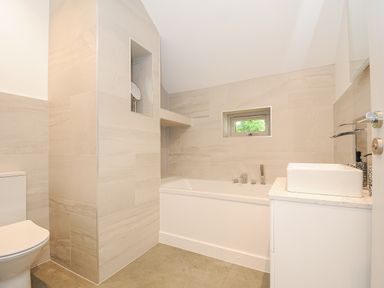 A bathroom with a bathtub toilet and sink at Cob Cottage near Rock