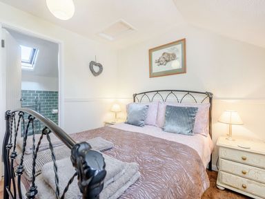 A bedroom with a metal bed frame bedside tables with lamps and towels on the bed at The Hayloft in St Florence