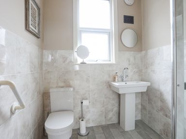 A bathroom with a toilet sink and a window at Llwyn Onn in Criccieth